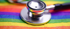 Stethoscope atop a rainbow flag 