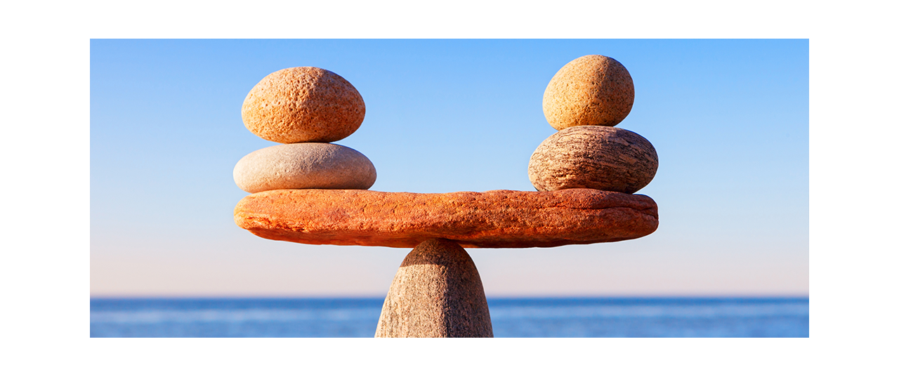 Seesaw made of stone balancing with two smaller stones