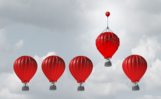 Five red hot air balloons in an overcast sky with the fourth from the last ascended higher than the others